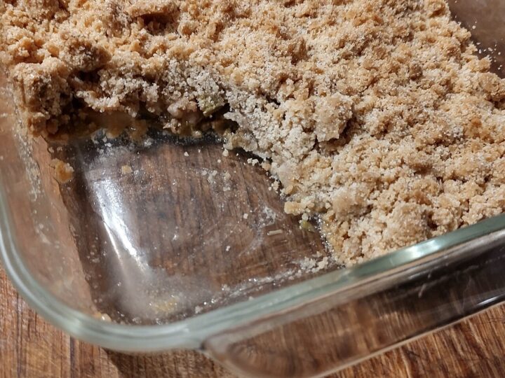 Crumble aux pommes entamé dans un plat en verre