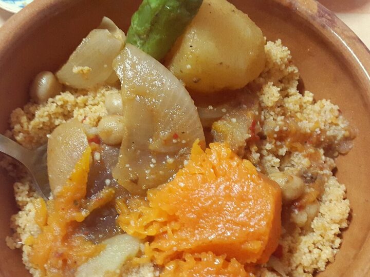 Assiette de couscous avec courge et autres légumes, sans viande visible.