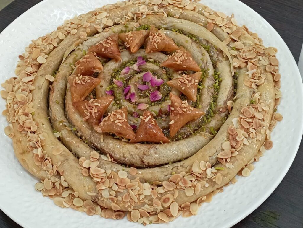 Grande m’hancha en spirale entourée d’amandes effilées et décorée au centre
