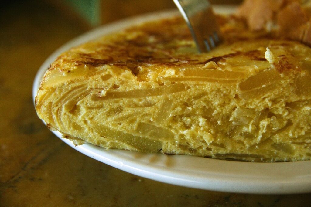 Coupe d’une omelette épaisse montrant les pommes de terre