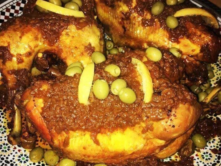 Poulets dorés avec une sauce aux oignons, des olives et des lanières de citron.