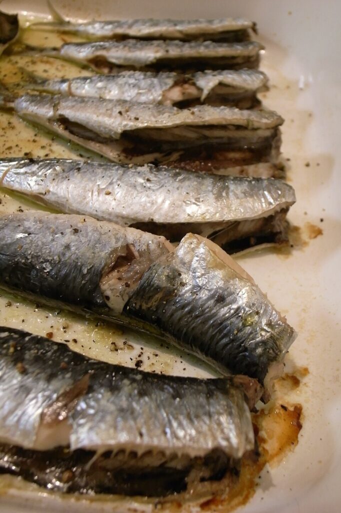 Sardines cuites alignées sur une assiette.