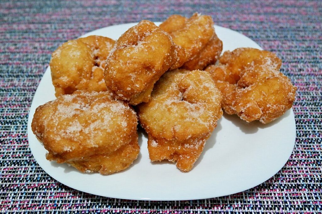 Sfenj dorés et saupoudrés de sucre sur une assiette
