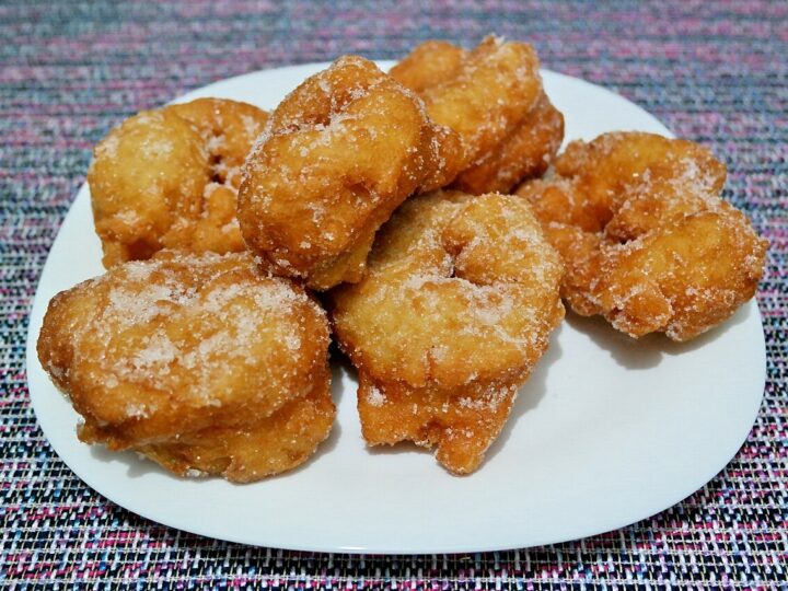 Sfenj dorés et saupoudrés de sucre sur une assiette